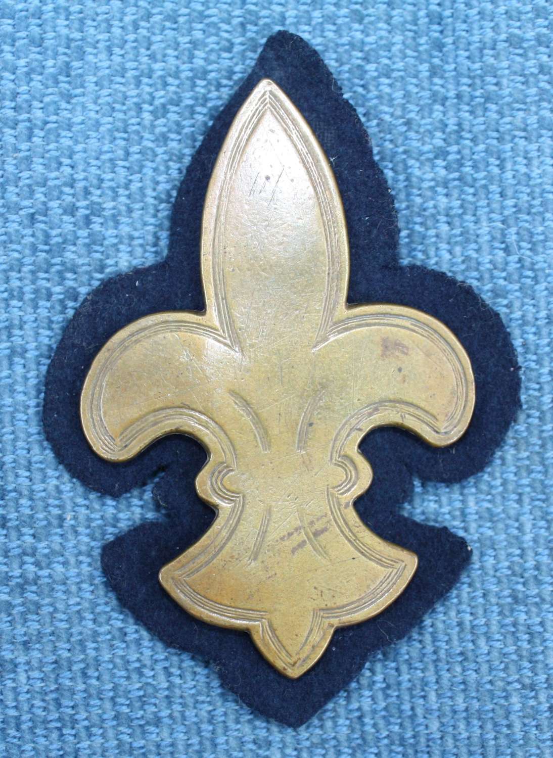 WW1 British Army Cavalry Arm Brass Trade Badge on Blue Felt.